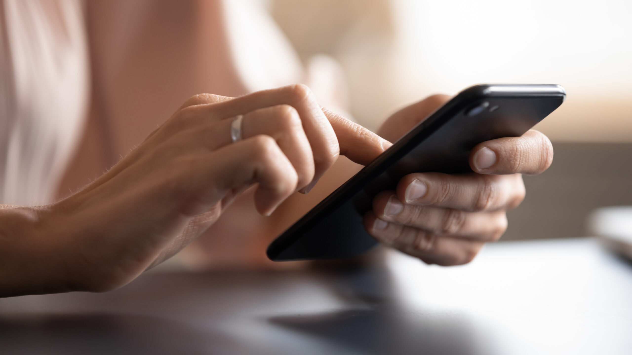 Eine Frau sucht an ihrem Handy online nach "Klimaanlage Willich"
